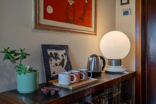 a table with coffee mugs and a lamp on it at La Casa dei Fichi in Gambassi Terme