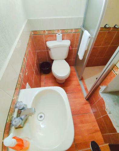 a small bathroom with a toilet and a sink at Gran Estancia in Esquipulas