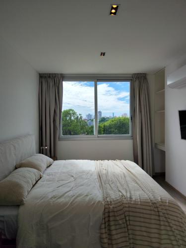 a bedroom with a bed and a large window at Depto 2 Dorm en Posadas - Lomas de Alem in Posadas