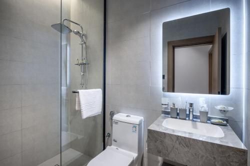 a bathroom with a toilet and a sink and a mirror at Delmar Luxury 3BR Apartment 6 in Jeddah