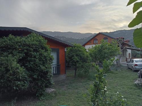 a house with a car parked in front of it at Charming wooden house with access to a large garden in Kemer