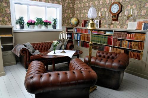 sala de estar con 2 sillas de cuero y mesa en Villa Gransholm en Gemla
