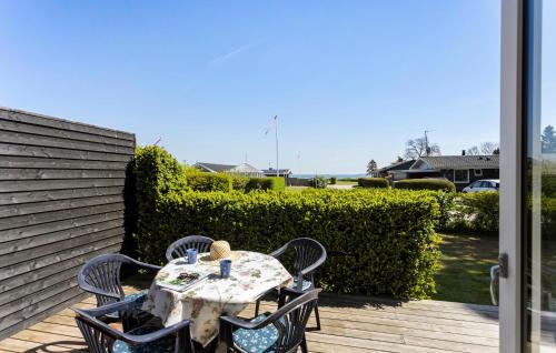 a table and chairs on a patio with a view of the ocean at 3 Bedroom Beautiful Home In Hesselager in Hesselager