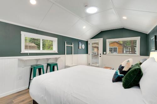 a bedroom with a large white bed and green walls at Riverside Colorado in Bellvue