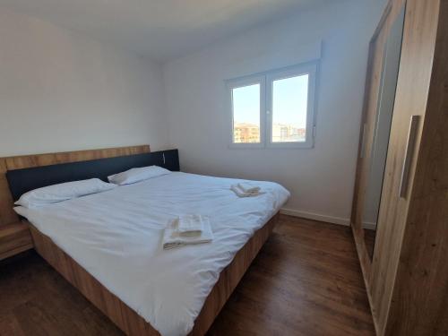 Un dormitorio con una cama con sábanas blancas y una ventana. en Paz Central Tower - Pets OK, en Castellón de la Plana