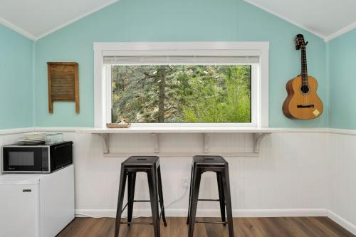 a kitchen with two stools and a window with a guitar at Riverside Colorado in Bellvue