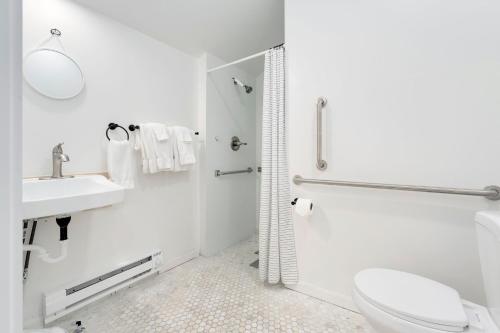 a white bathroom with a toilet and a sink at Riverside Colorado in Bellvue