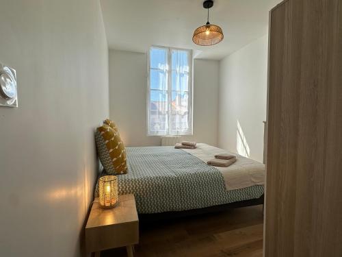 a small bedroom with a bed and a window at Chez Camille & Emma - Hyper Centre Climatisé in Rochefort