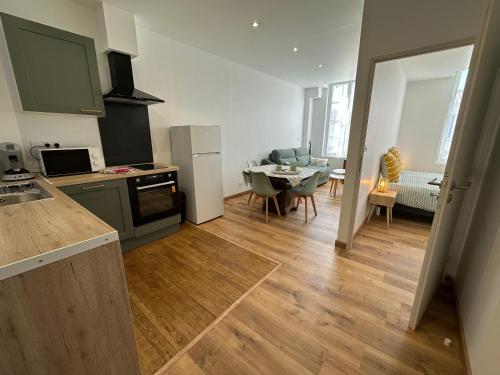 une cuisine et un salon avec une table et une salle à manger dans l'établissement Chez Camille & Emma - Hyper Centre Climatisé, à Rochefort