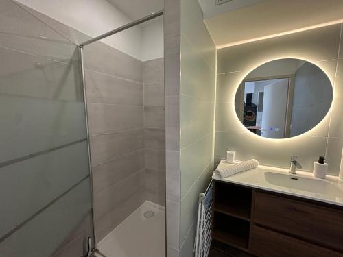 a bathroom with a shower and a sink and a mirror at Chez Camille & Emma - Hyper Centre Climatisé in Rochefort