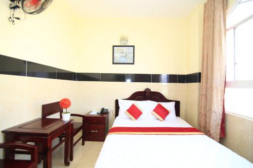 a bedroom with a bed and a desk and a bed sidx sidx sidx at Truong Giang Hotel in Ho Chi Minh City