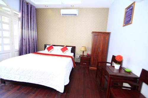 a bedroom with a white bed and a wooden floor at Truong Giang Hotel in Ho Chi Minh City