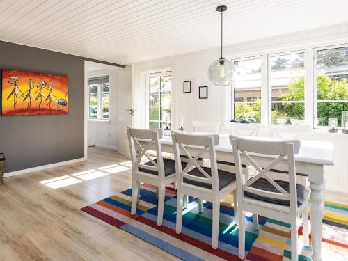 a dining room with a white table and chairs at Cozy Summer House Near Ore Strand in Vordingborg