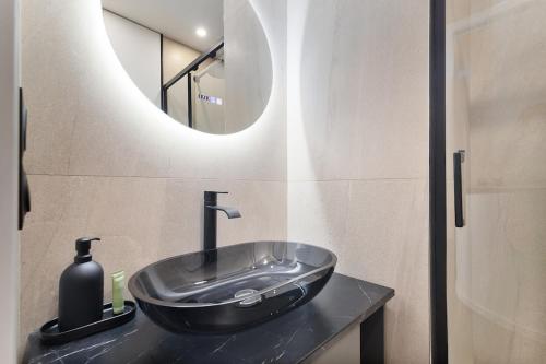 une salle de bain avec un lavabo et un miroir dans l'établissement LaSuite Montmartre, à Paris