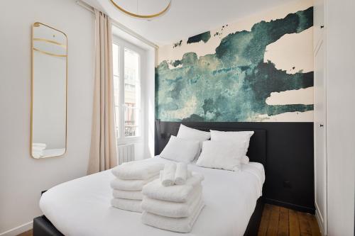 une chambre avec un lit avec des serviettes dessus dans l'établissement LaSuite Montmartre, à Paris