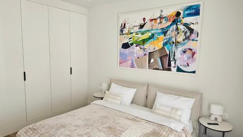 a bedroom with a bed and a painting on the wall at Lustica Bay Centrale 7a4 in Tivat