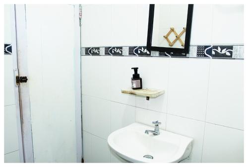 a white bathroom with a sink and a mirror at Casa Bambudas in Rincón