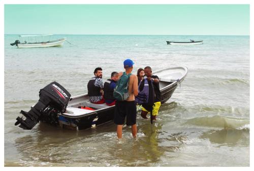 a group of people standing in the water next to a boat at Casa Bambudas in Rincón