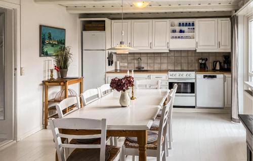 a kitchen with a table and chairs and a kitchen with white cabinets at 4 Bedroom Beautiful Home In Skagen in Skagen
