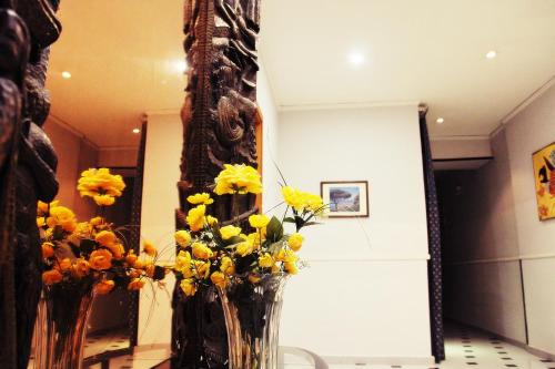 two vases filled with yellow flowers on a table at Hotel Luna Rossa in Naples