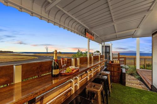 a bar with a bottle of wine and a plate of food at Quirky Black Shack in Burnett Heads