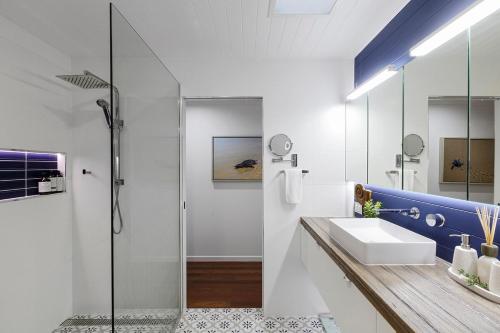 a bathroom with a sink and a shower at Quirky Black Shack in Burnett Heads
