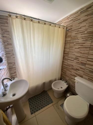 a bathroom with a white toilet and a sink at Buen Descanso 2 in San Pedro