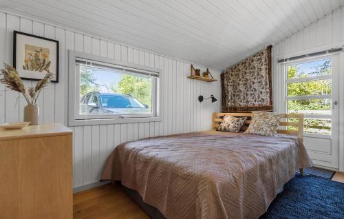 a bedroom with a bed and two windows at 3 Bedroom Nice Home In Glesborg in Glesborg