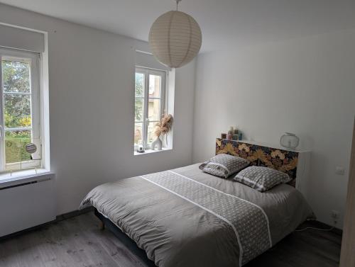 une chambre avec un lit et deux fenêtres dans l'établissement Maison agréable au coeur de Bayeux !, à Bayeux