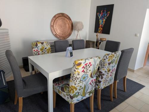 une salle à manger avec une table et des chaises blanches dans l'établissement Maison agréable au coeur de Bayeux !, à Bayeux