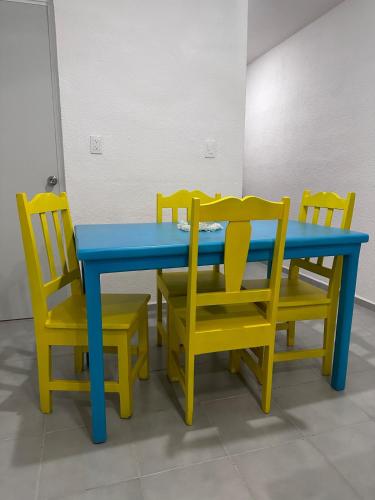 a blue and yellow table and four chairs at Casa Flamboyán in Santa Bárbara