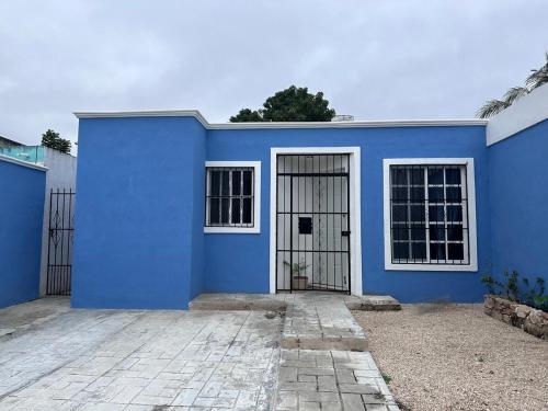 a blue house with a gate in front of it at Casa Flamboyán in Santa Bárbara