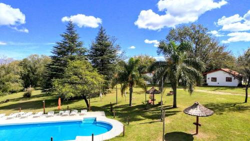 ein Pool mit Stühlen und ein Haus im Hintergrund in der Unterkunft Lomas de Belgrano Oficial cabaña 1 in Villa General Belgrano