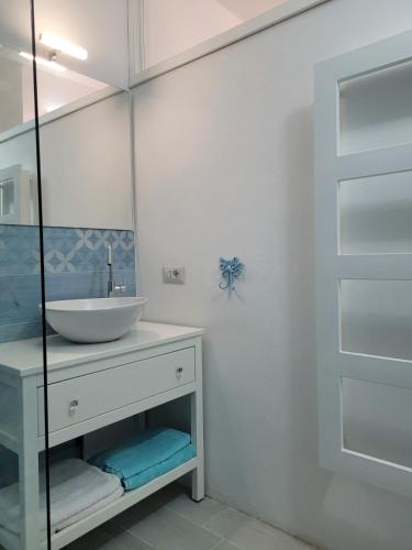 a white bathroom with a sink and a mirror at Casa Tiemme Vista Mare in Costa Paradiso