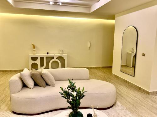 a living room with a white couch and a mirror at Eden Vibes GUELIZ in Marrakech