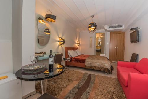 a living room with a bed and a red couch at Amfitriti Palazzo in Nafplio