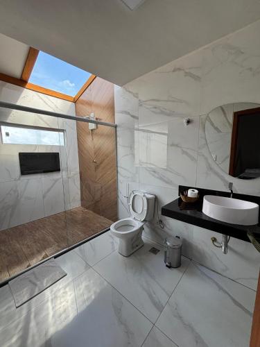 a bathroom with a shower and a toilet and a sink at Skyloft in Governador Valadares