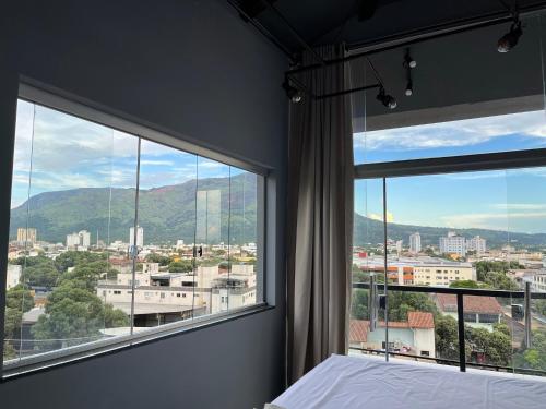 a bedroom with a bed and a large window at Skyloft in Governador Valadares