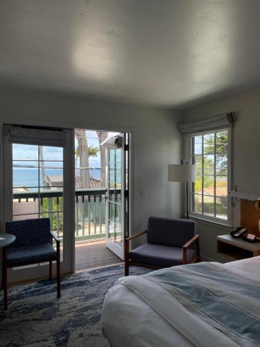 a bedroom with a bed and a balcony with the ocean at Carmel Beach Hotel in Carmel