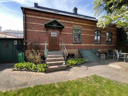 a brick house with a brown door and stairs at Sahlin - Ängelholm in Ängelholm
