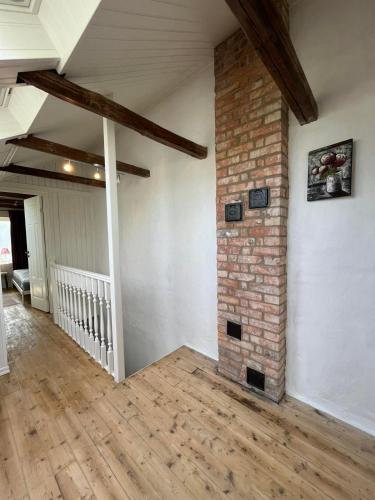 an empty living room with a brick pillar and wooden floors at Sahlin - Ängelholm in Ängelholm