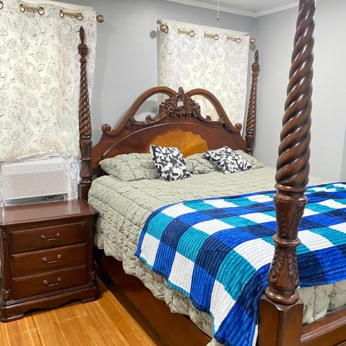 a bedroom with a bed with a blue and white blanket at Rehan in Teaneck