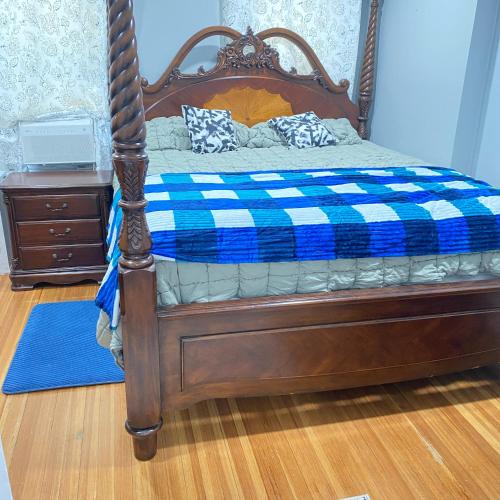 a bed with a blue and white checkered blanket at Rehan in Teaneck