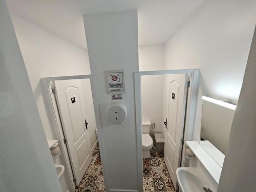 a white bathroom with two mirrors and a toilet at La Casona de Antonio Sosa in Santa Maria de Guia de Gran Canaria