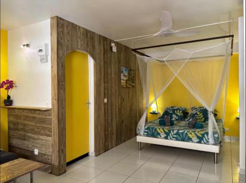 un dormitorio con una cama con dosel en Gwada-Zen-Breizh 3 hébergements au choix 1 avec piscine privée, 1 avec jacuzzi privé, 1 simple sans piscine ni jacuzzi, en Deshaies