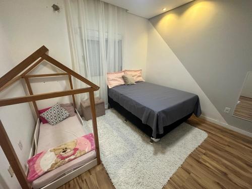 a small bedroom with a bed and a mirror at Casa de 2 dormitórios com piscina in Pelotas