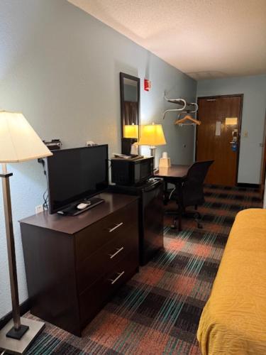 a hotel room with a bedroom with a bed and a desk at SUNRiSE INN in Greenwood