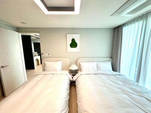 two beds sitting next to each other in a bedroom at THE DECEMBER STAY Busan Songdo Ocean Terrace in Busan
