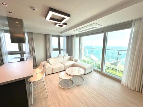 a living room with a couch and a table and chairs at THE DECEMBER STAY Busan Songdo Ocean Terrace in Busan