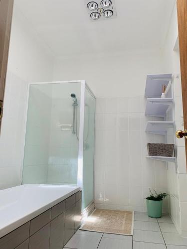 a white bathroom with a shower and a tub at Rose Garden Retreat in Timboon